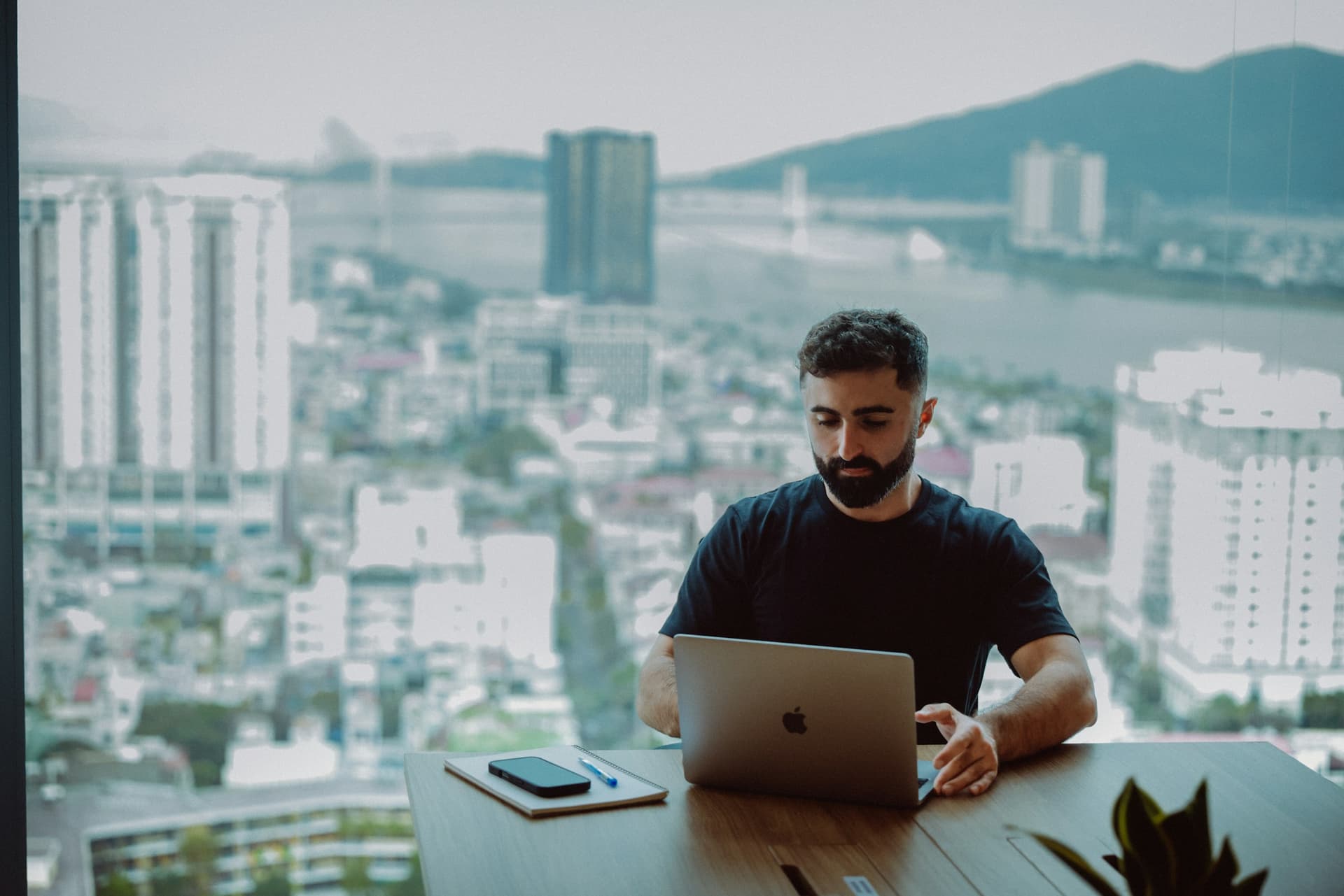 A business professional reviewing analytics on a monitor in a modern, naturally lit office.